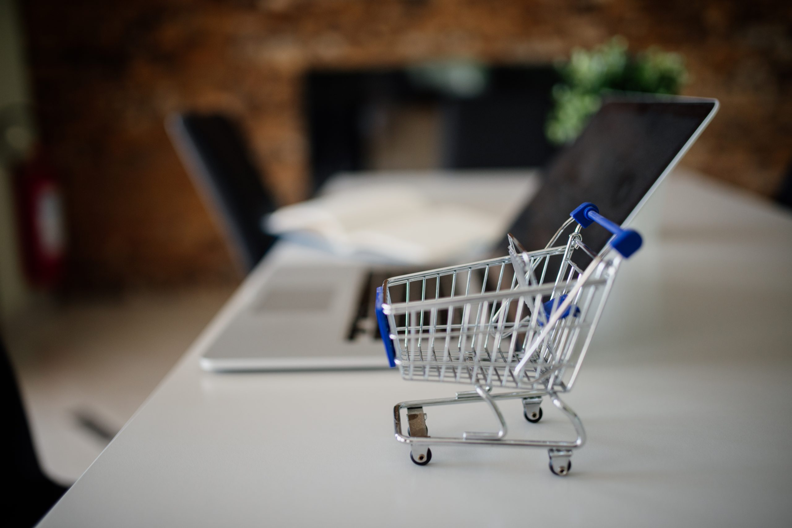 Mini shopping cart beside a laptop representing ecommerce integrations and developer QA
