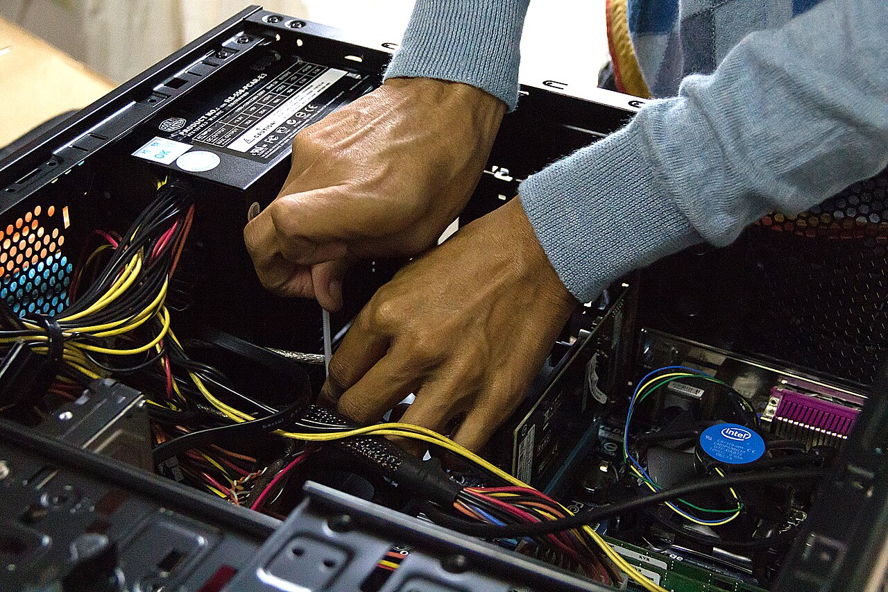 Computer technician performing careful hardware maintenance