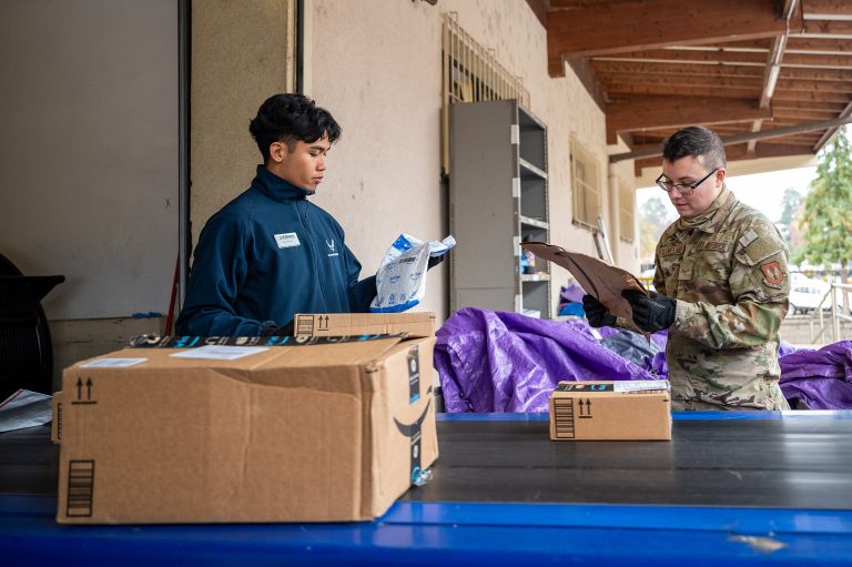 Postal workers sorting packages, representing reliable ecommerce shipping updates