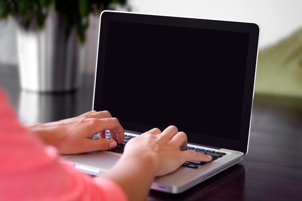 Business professional reviewing search data on a laptop to identify local customer demand