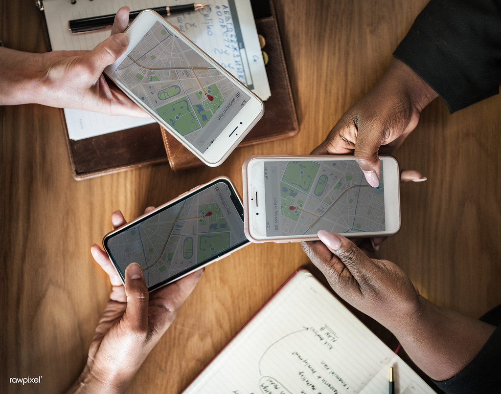 Business team comparing map results on smartphones