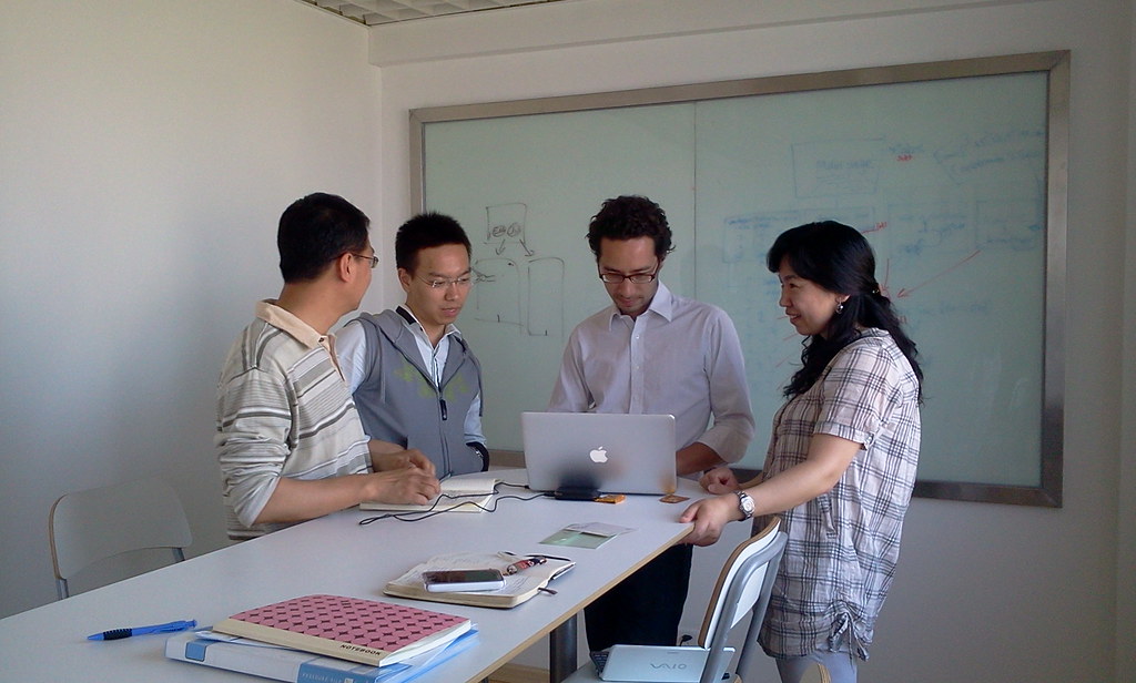 Business team meeting around a laptop to align website growth with sales capacity