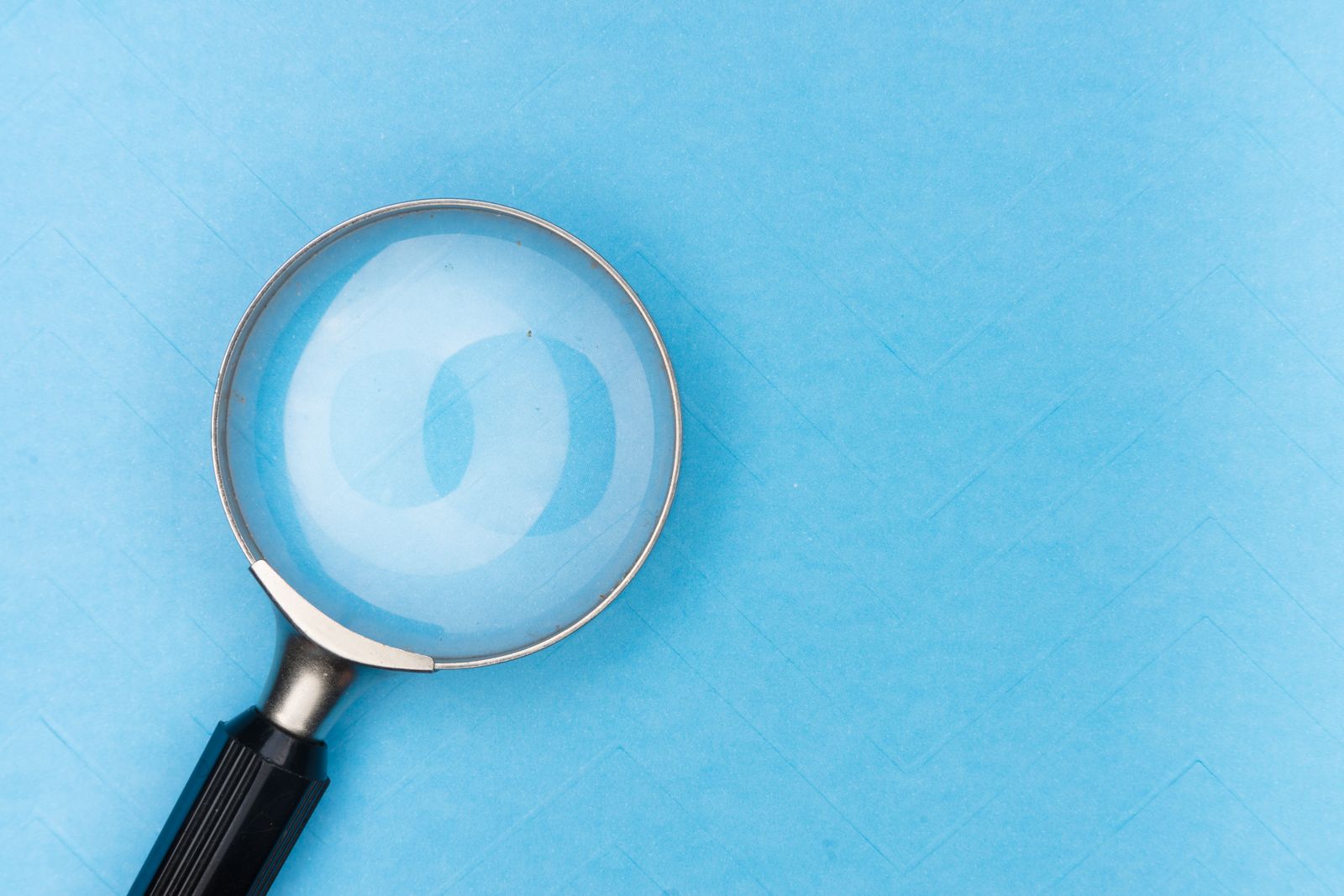Magnifying glass resting on a blue surface